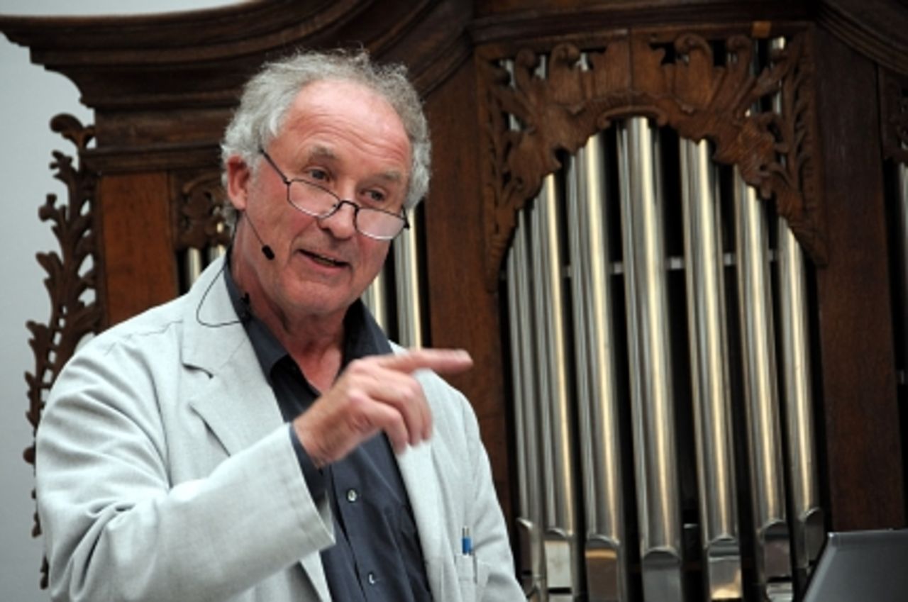 Foto: Professor Volkwin Marg am Rednerpult vor einer Orgel