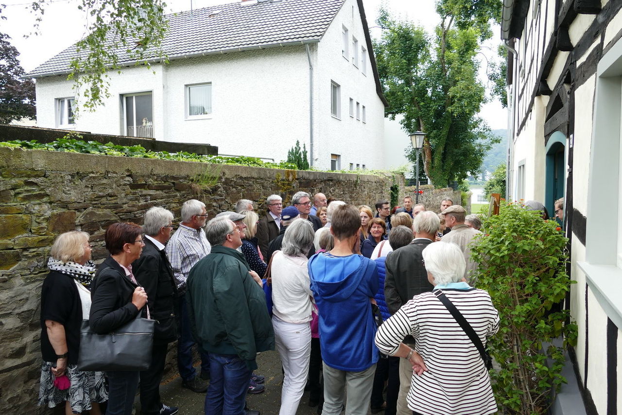 Besuchergruppe beim Tag der Architektur in einer Gasse mit Natursteinmauer