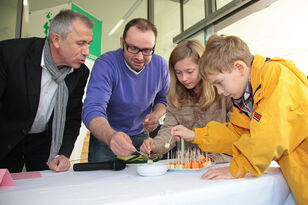 Zwei Kinder und zwei Herren probieren die Snacks