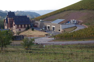 Blick auf das Hauptgebäude und das neue Wirtschaftsgebäude, dass direkt an den Hang eines Weinberges gebaut wurde. In der Ferne sieht man das Tal.