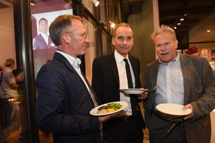Drei Herren beim Buffet mit ihren Tellern in den Händen