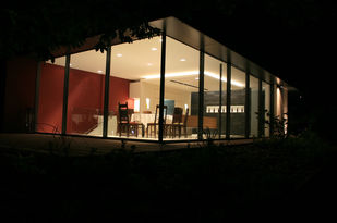 Foto: Blick auf die bei Nacht hell erleuchtete Pinoteca. Durch die raumhohen Glaselemente ist der ganze Raum ersichtlich.