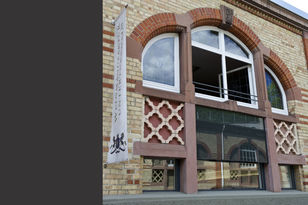 Blick auf die Außenfassade aus Backstein. Auffällig an der Fassade ist das Motiv des Kleeblattes.