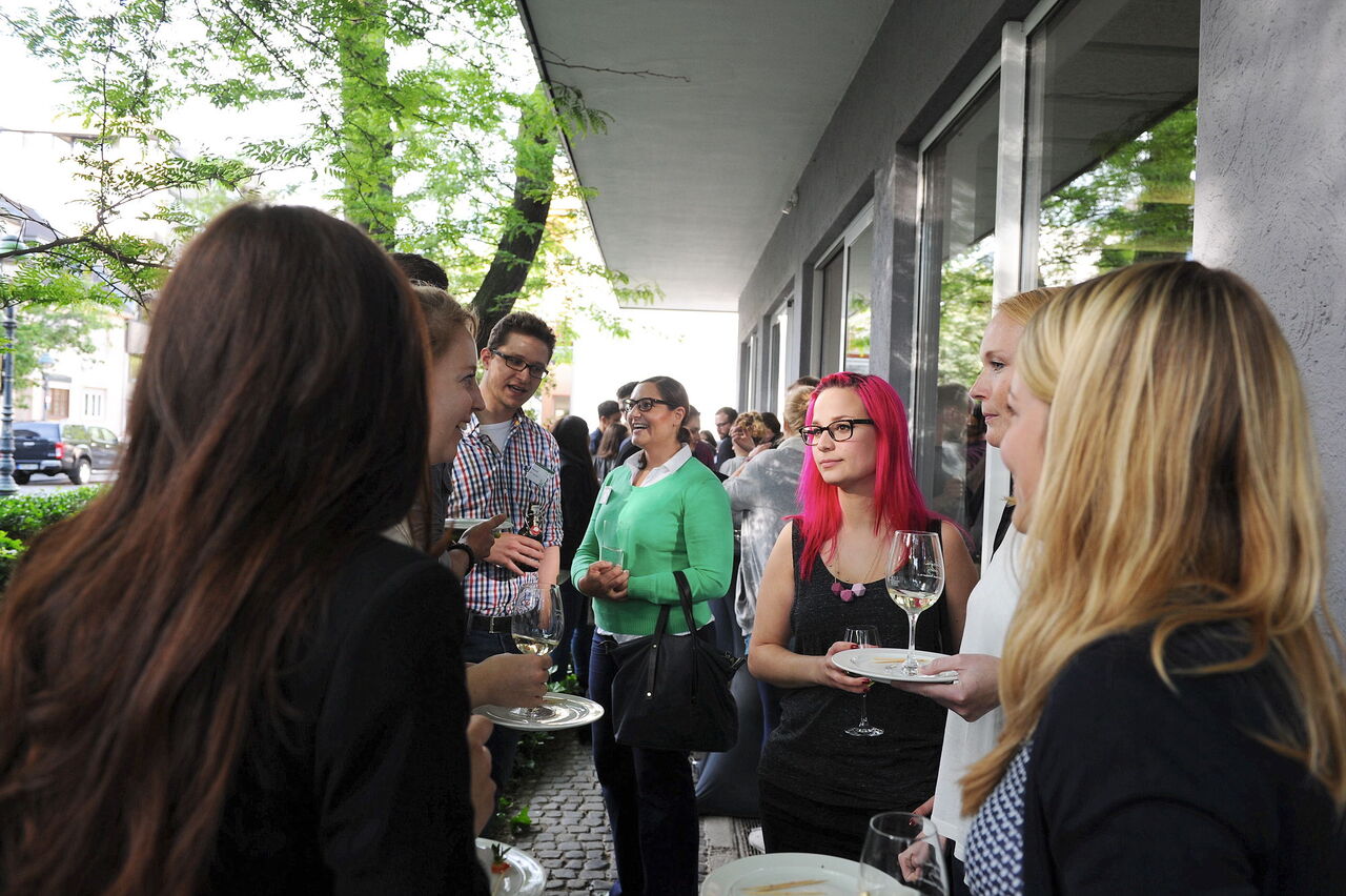 Die Besucher versammeln sich draußen für Gespräche und Wein 