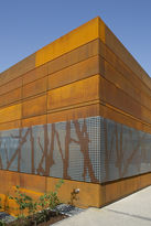 Foto: Fassade aus Rostbraunen Stahlplatten, im unteren Bereich des Gebäudes, ein graues Fassadenblech mit dem Aufdruck knorriger Reben.