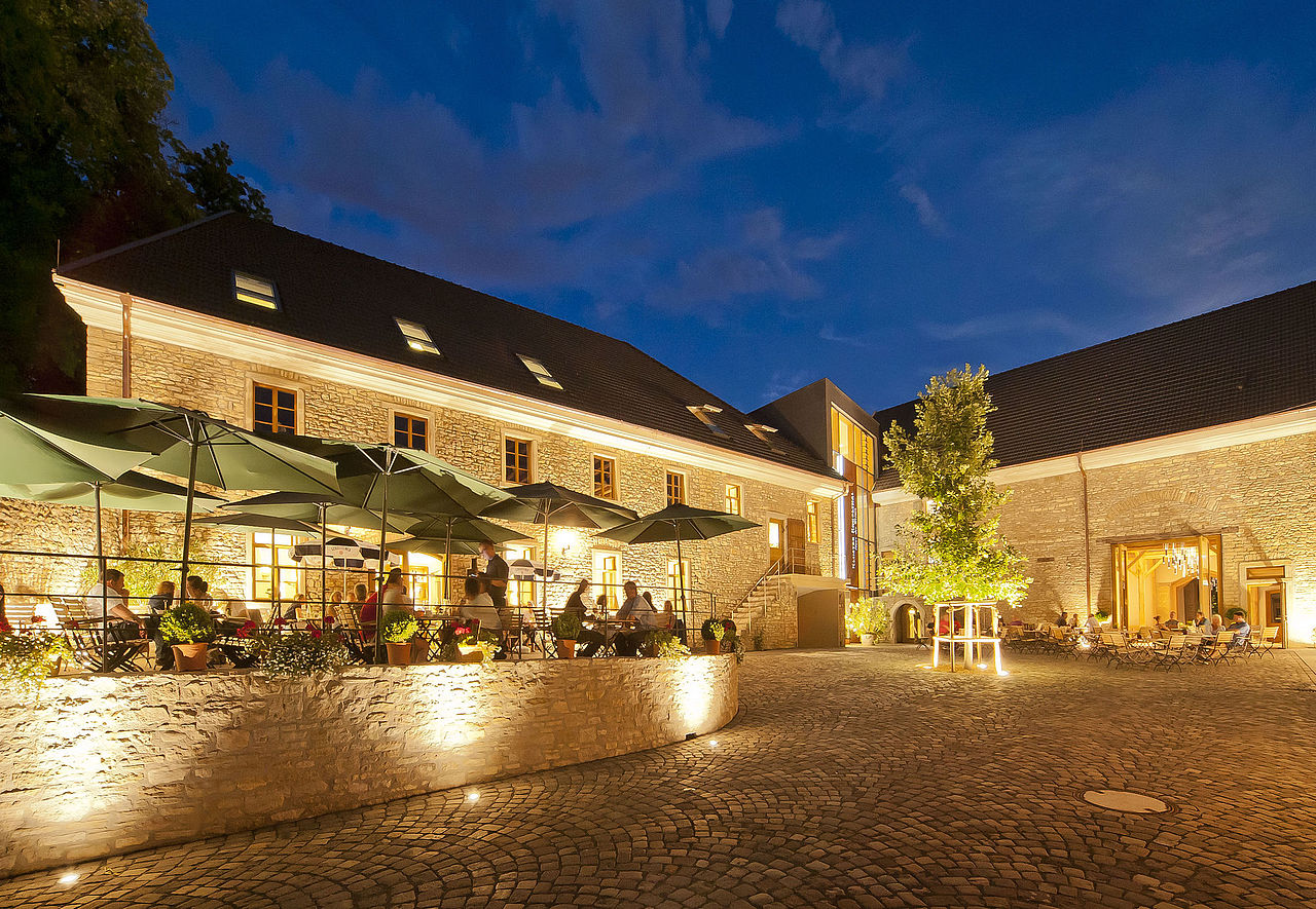 Foto: Nachts zieht das Kloster durch seinen hell erleuchteten, neuen Verbindungsbau mit Glasfassade die Blicke auf sich.