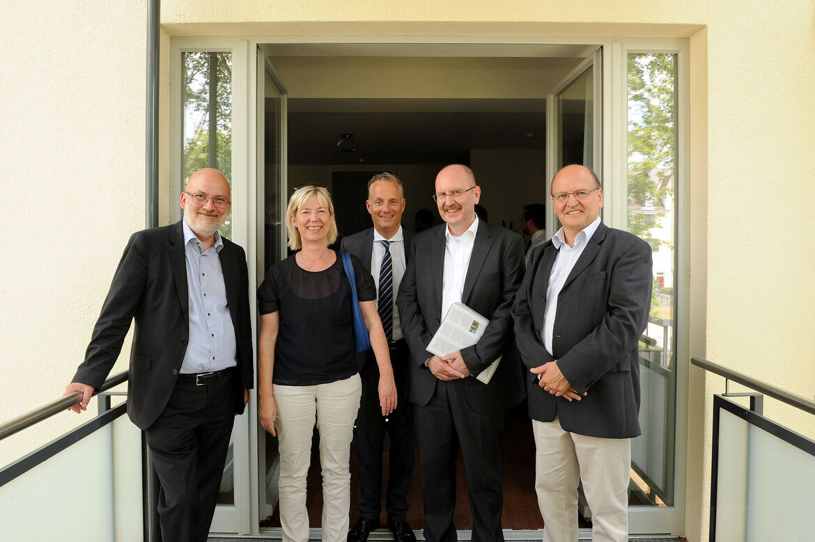 Foto: Die Ministerin mit den beiden Verbandsdirektoren des vdw und dem Präsdium der Kammer auf einem Balkon in den Hohenzollernhöfen in Ludwigshafen