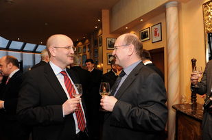 Foto: Zwei Herrn mit Weingläsern im entspannten Gespräch