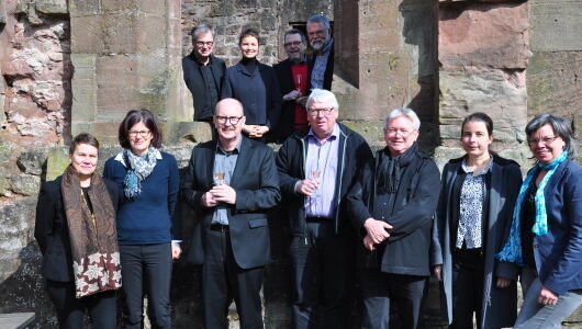 Mehrere Menschen versammelt aufgestellt vor einem Kloster