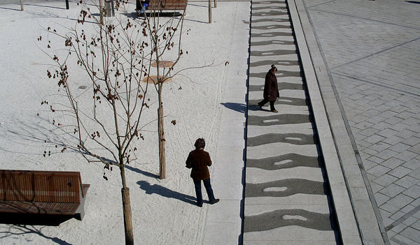 Foto: Blick auf den gepflasterten, winterlichen Kornmarkt von erhöhter Position, zwei Fußgänger bewegen sich über den Platz.