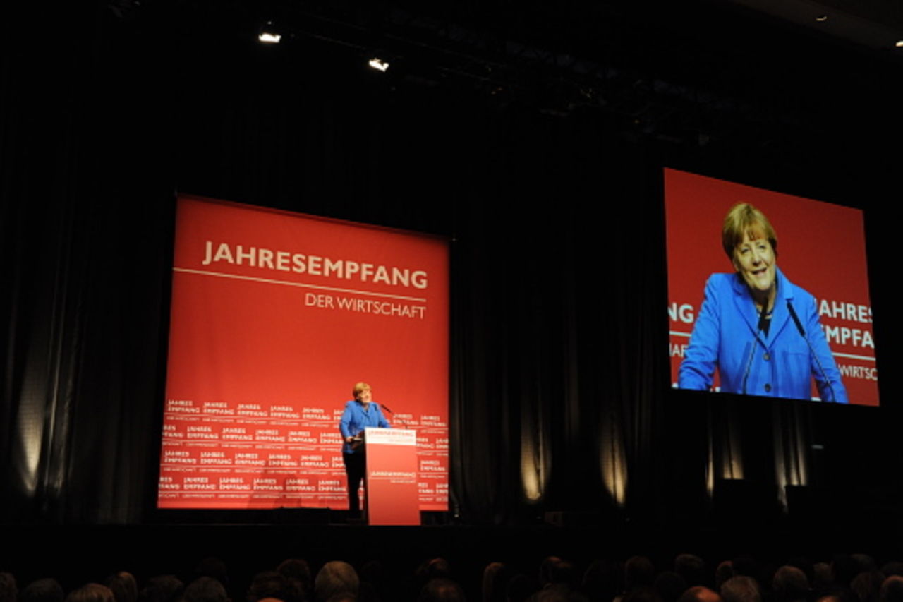 Foto: Die Bundeskanzlerin am Rednerpult kann über Großbildleinwand im ganzen Saal gesehen werden