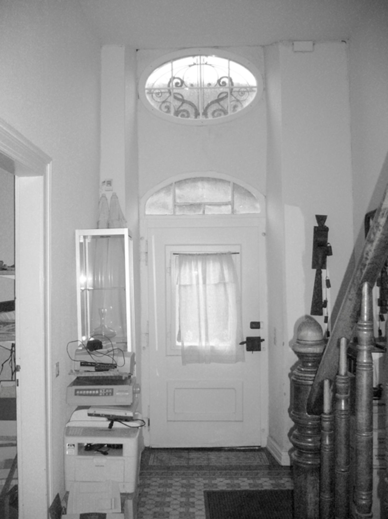 Foto: Blick auf den Eingangsbereich von innen vor der Sanierung, mit rustikaler Holztreppe.