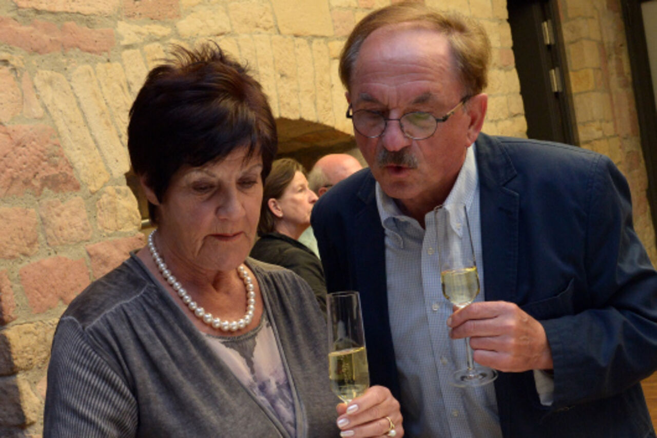 Foto: Zwei Besucher des Abends tragen sich in Gästebuch ein