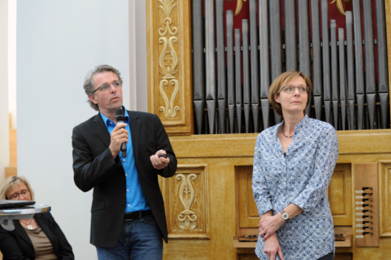 Architekt Winfried Klein und Bauherrin Antje Stamm sprechen ins Mikrofon 