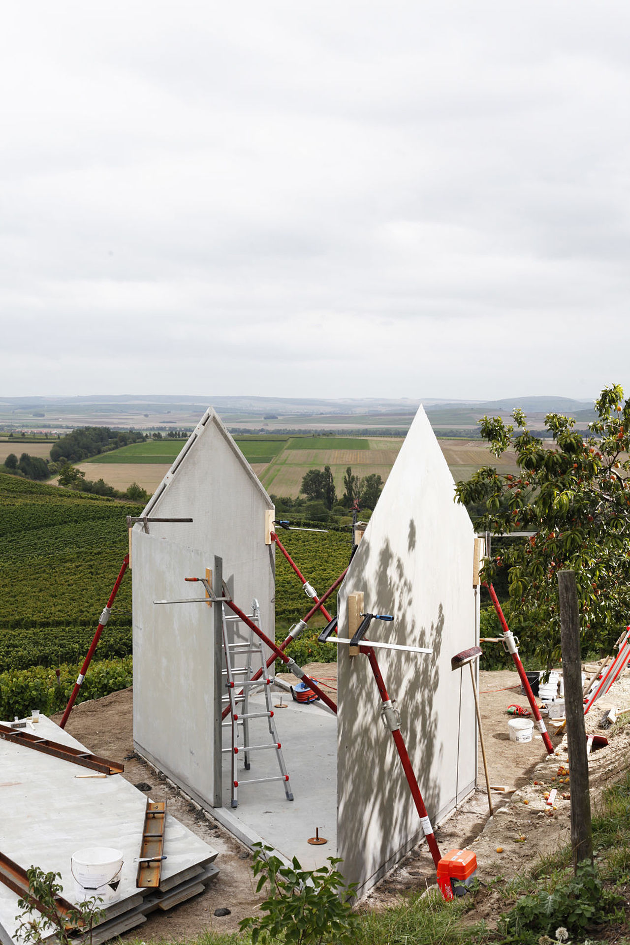 Foto: Blick auf das noch nicht fertig gestellte Weinbergshaus. Im Hintergrund sieht man die Weinberge.