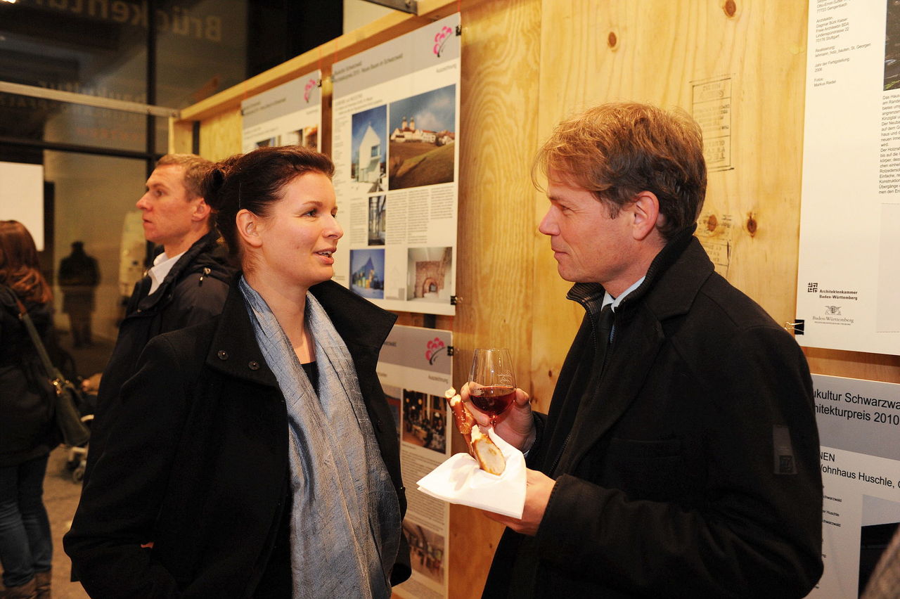 Foto: Menschen im Gespräch vor der aktuellen Ausstellung im Zentrum Baukultur