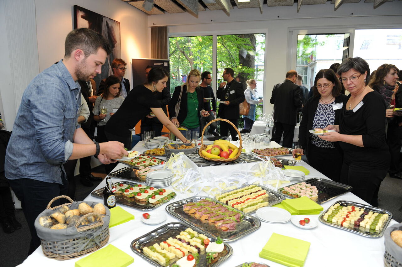 Die Besucher bedienen sich an dem Tisch mit Fingerfood 