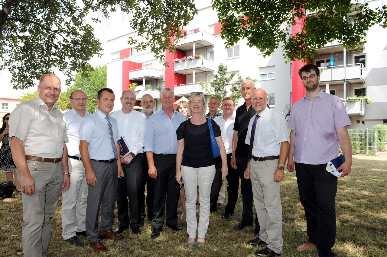 Foto: Gruppenbild der Teilnehmer im Schatten eines Baumes vor dem Projekt