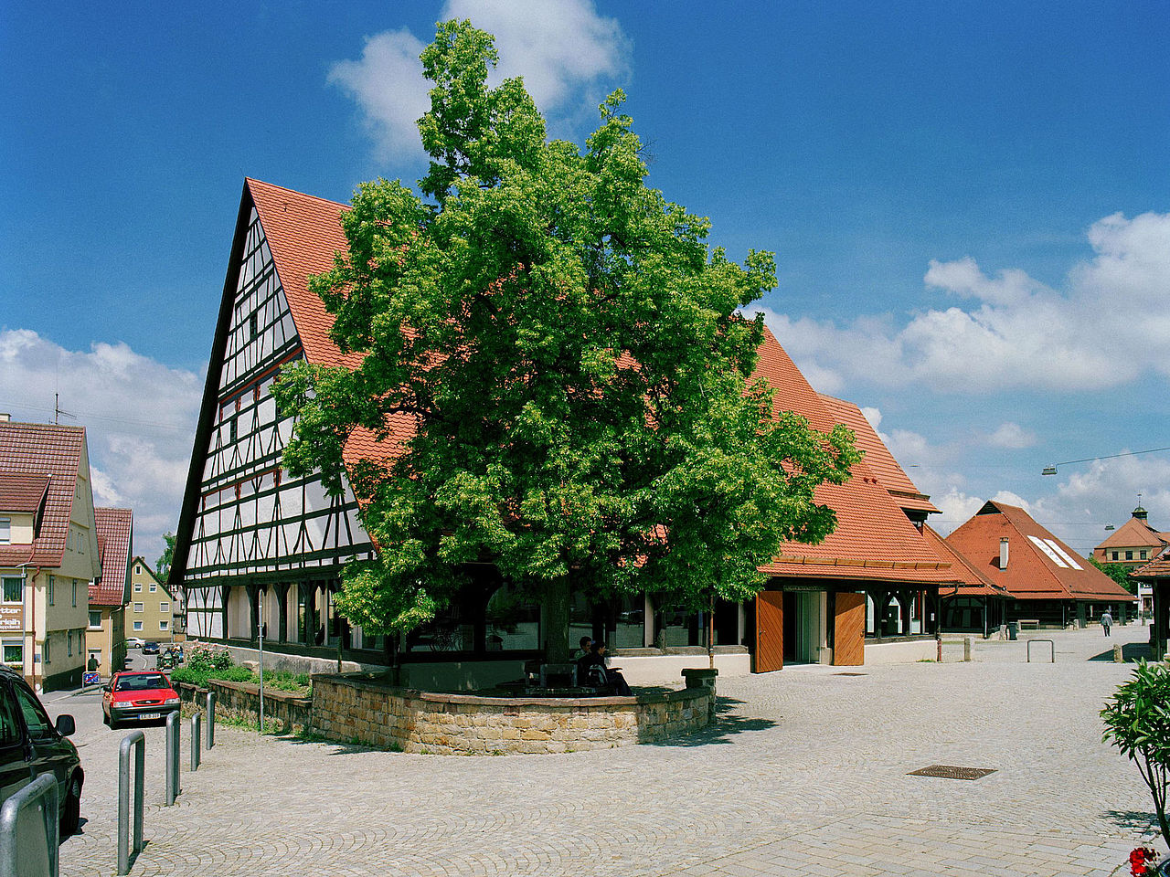 Blick von der Straße auf die denkmalgeschützte Kelter mit ihrem hohen Satteldach und Giebelwand in Sichtfachwerk