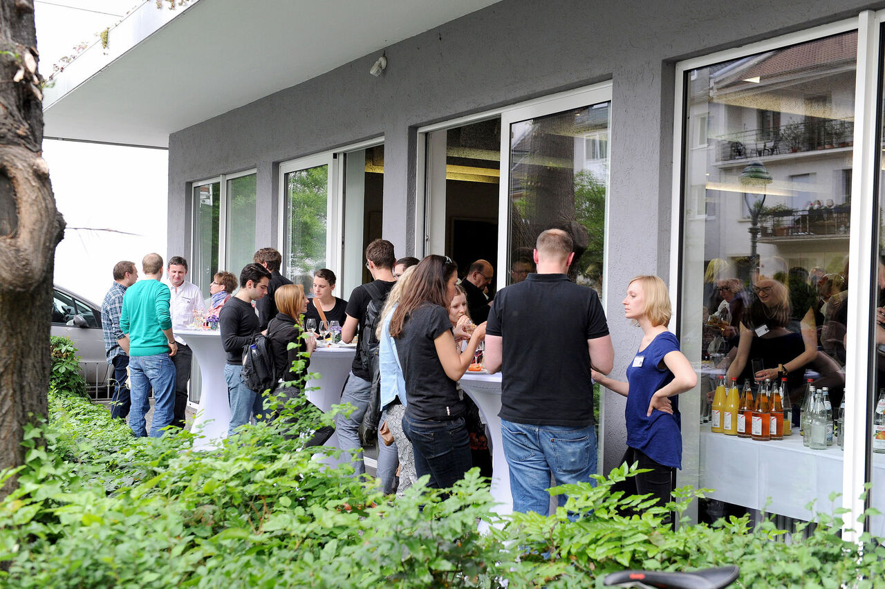 Besucher unterhalten sich im Außenbereich des Veranstaltungsort.