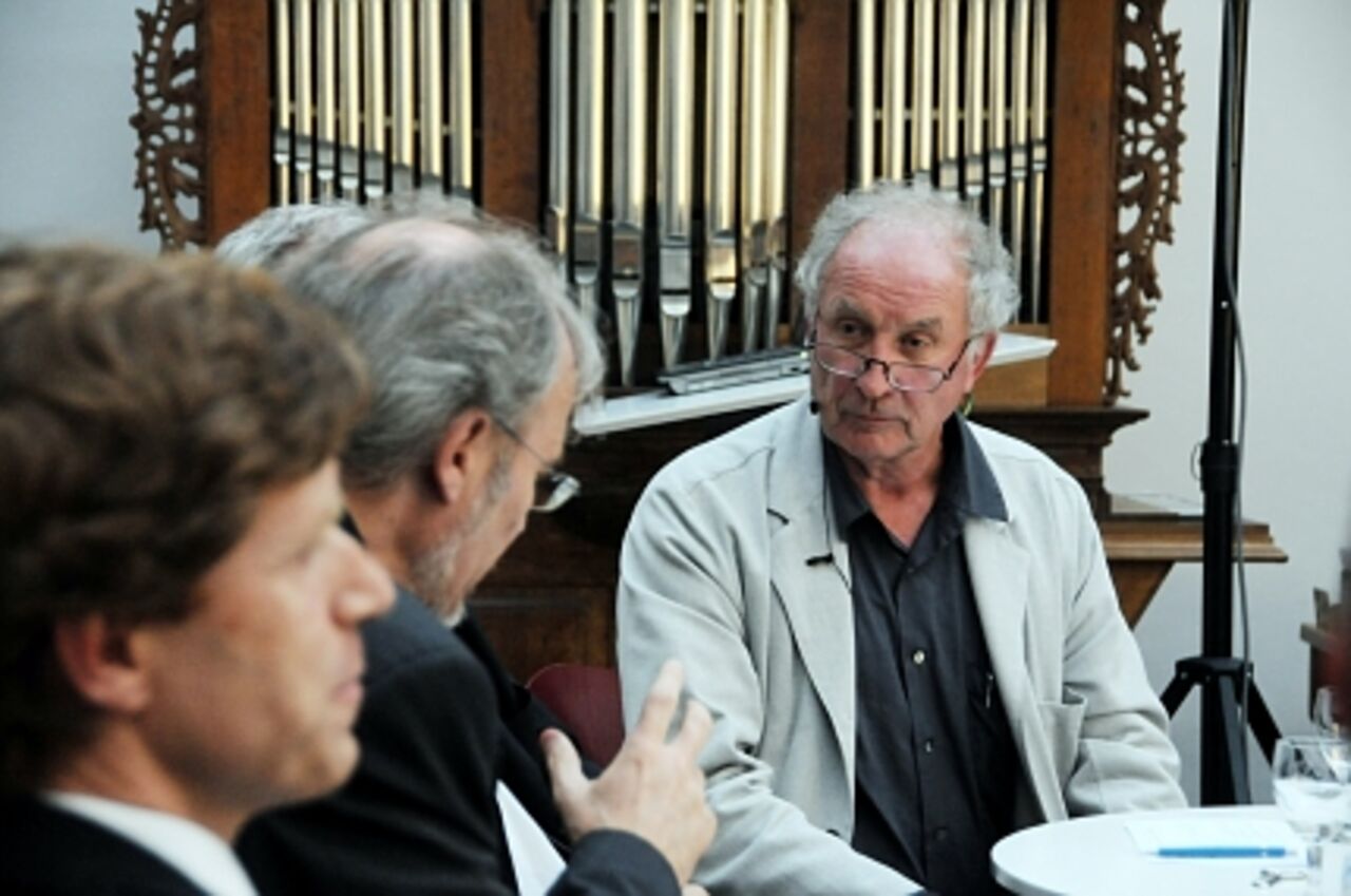 Foto: Der Moderator spricht in der Diskussion Professor Marg an.