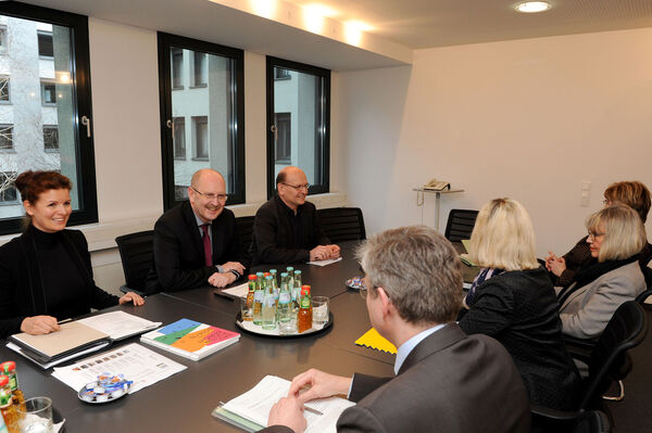 Mehrere Personen sitzen an einem Tisch und unterhalten sich.