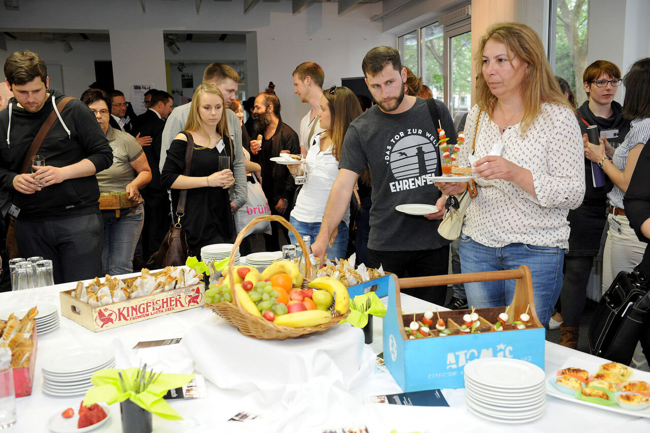 die Besucher probieren sich an dem Fingerfood-Buffett