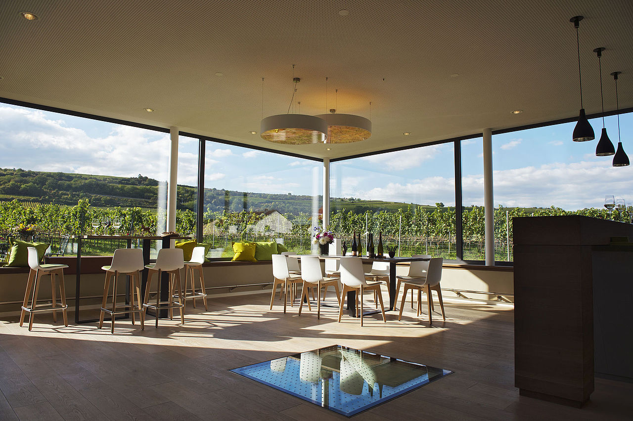 Innenraum der Weinprobierstube mit Ausblick auf Weinberge