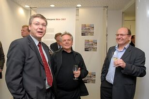 Foto: Gutgelaunte Gäste der Ausstellung im Gespräch mit Gläsern in den Händen