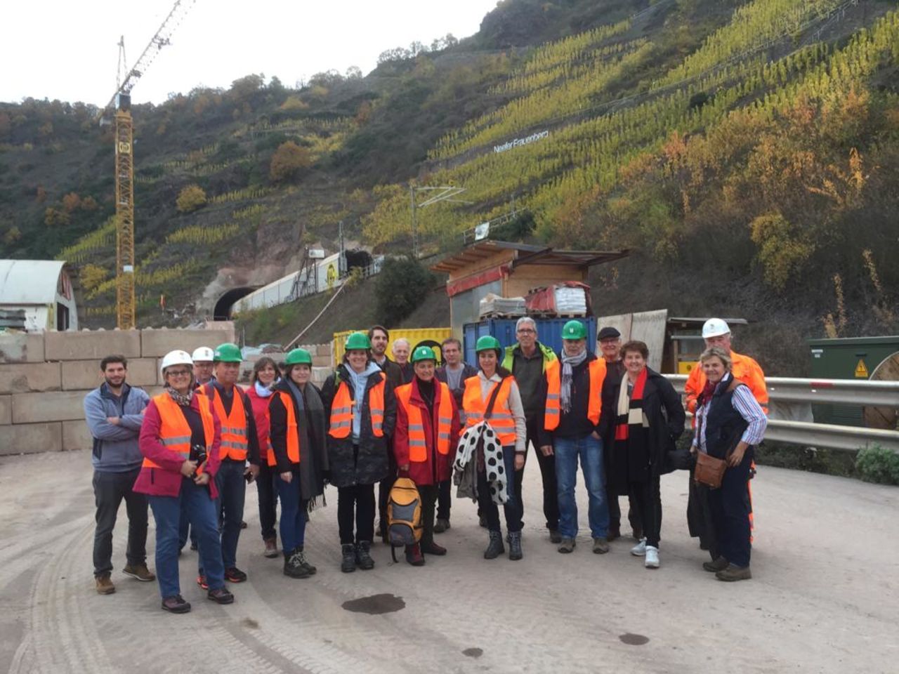 Gruppenfoto des Besucherteams auf der Baustelle, ca. 20 Personen.