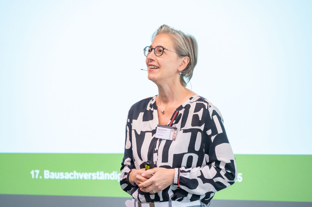 Nadine Metlitzky steht vor der Leinwand bei ihrem Vortrag.