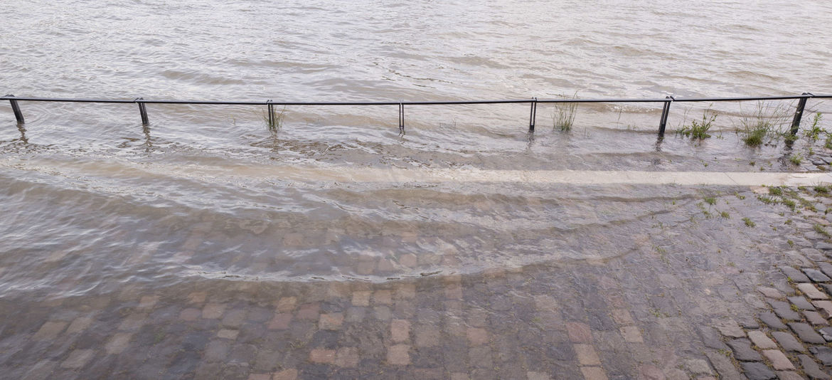 Überflutetes Geländer am Flussufer - Hochwasser