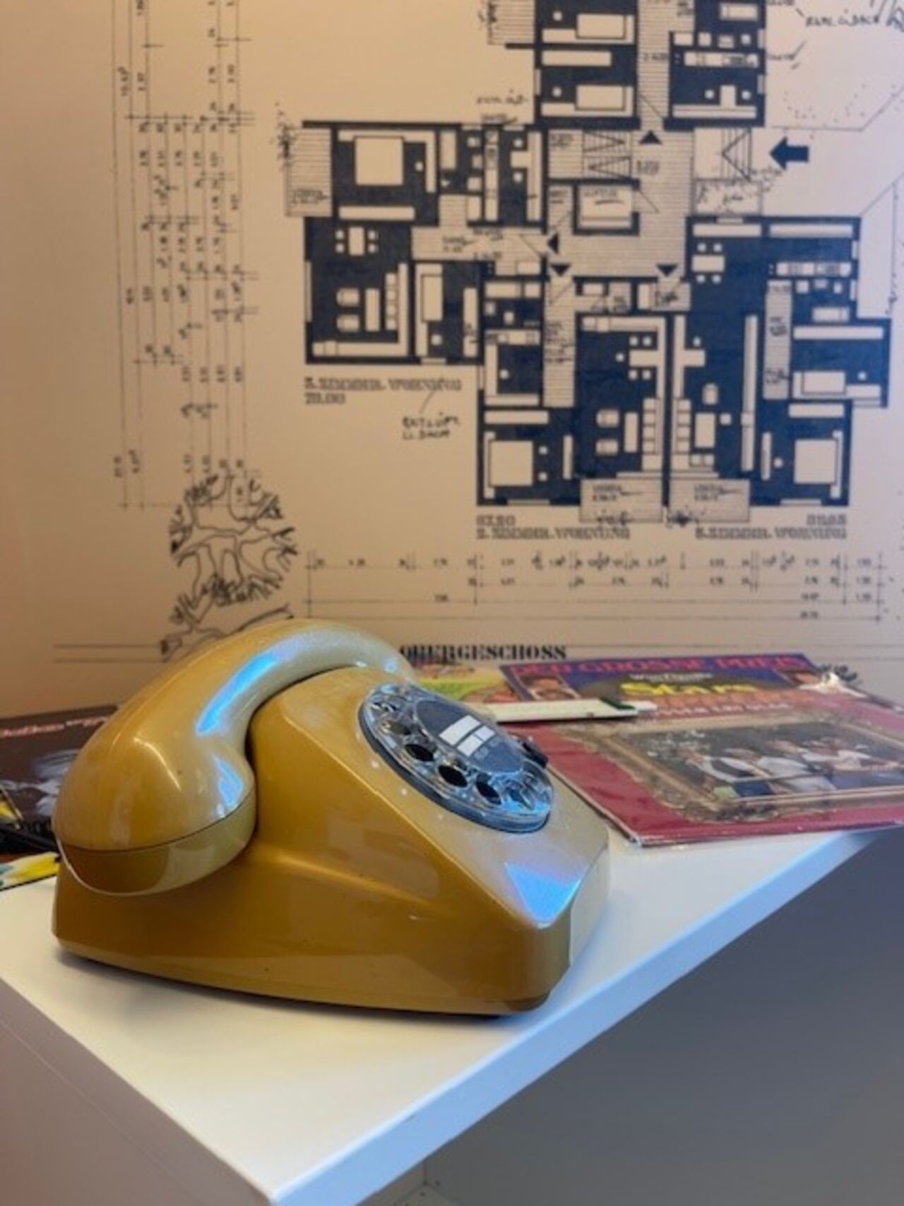 Vintage-Telefon vor Bauplan als Ausstellungsdetail