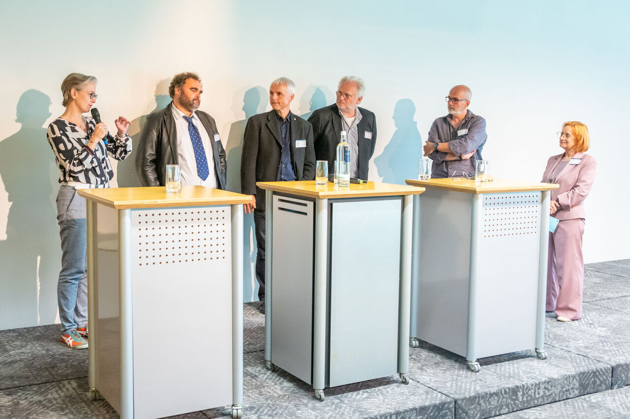 Referenten stehen zur Diskussionsrunde zusammen