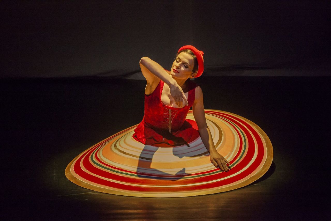 Tänzerin mit Kostüm aus dem Traidischen Ballett sitzend