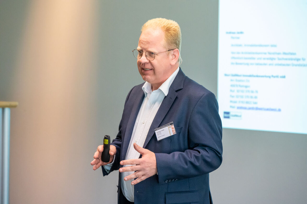Andreas Jardin steht vor der Leinwand bei seinem Vortrag