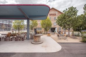 Ansicht der Markthalle, im Vordergrund eine ehemalige Tankstelle