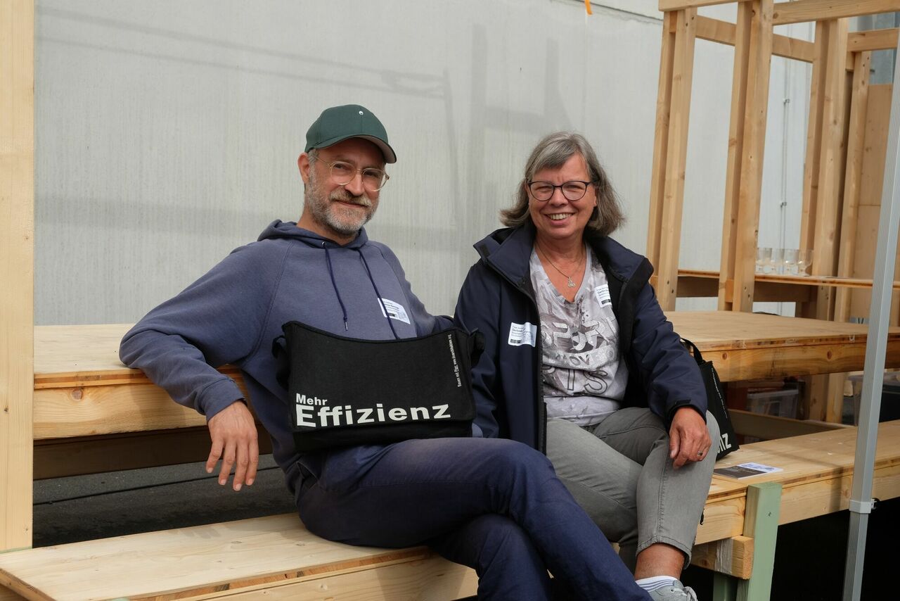 zwei Personen sitzend mit Blick in die Kamera