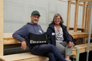 zwei Personen sitzend mit Blick in die Kamera