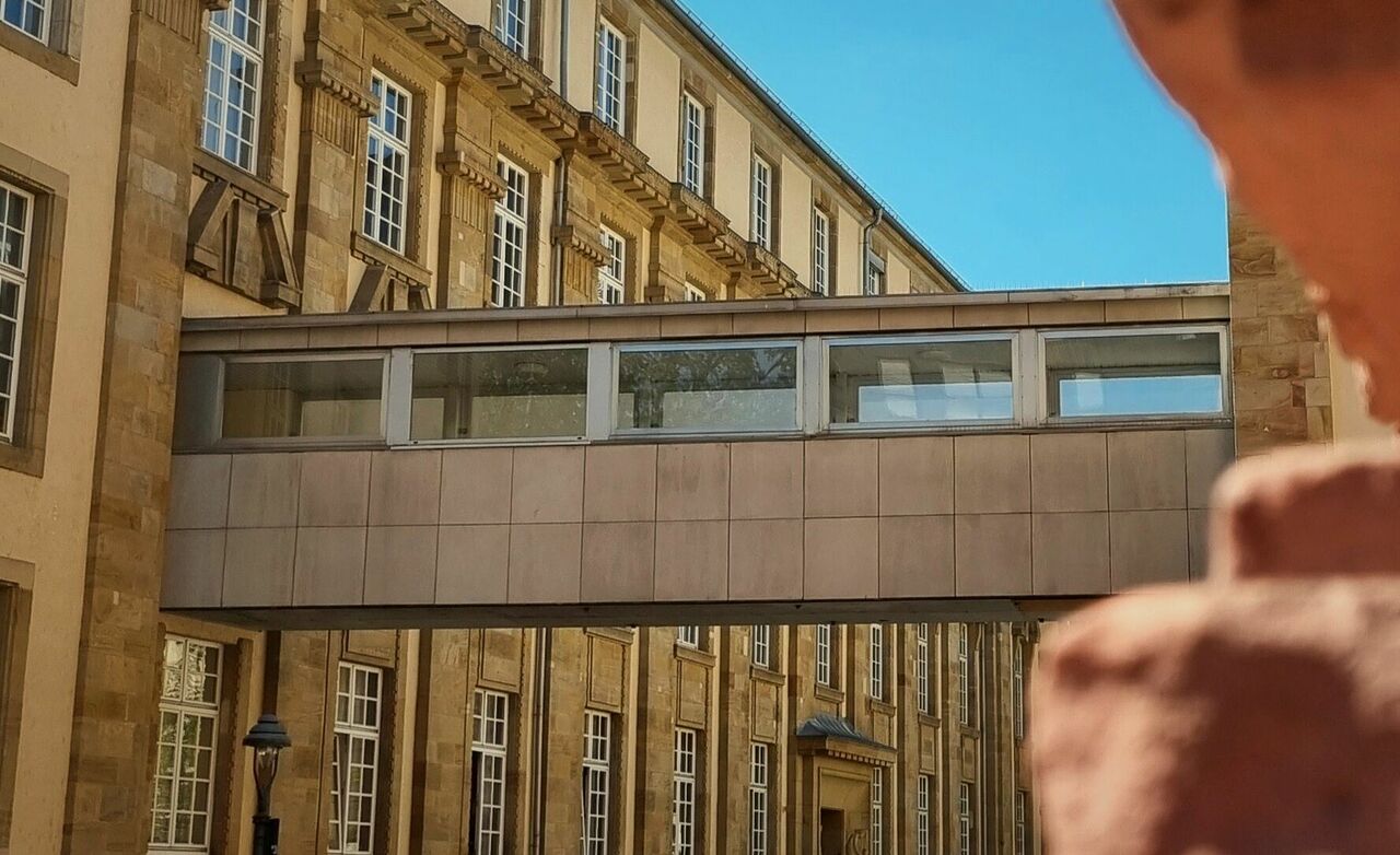 Verbindungsgang zwischen historischen Häusern in Stahl und Glas