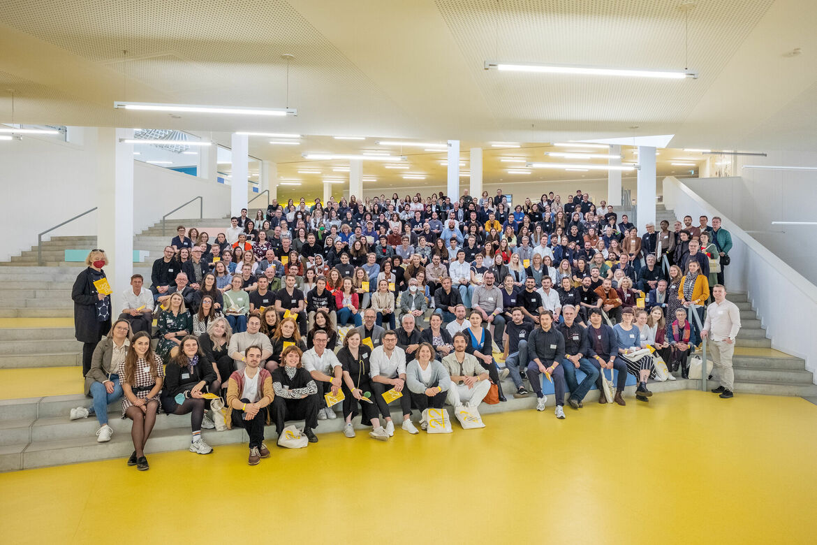 Gruppenfoto der 300 Teilnehmenden auf einer Treppe des Veranstaltungsortes versammelt.