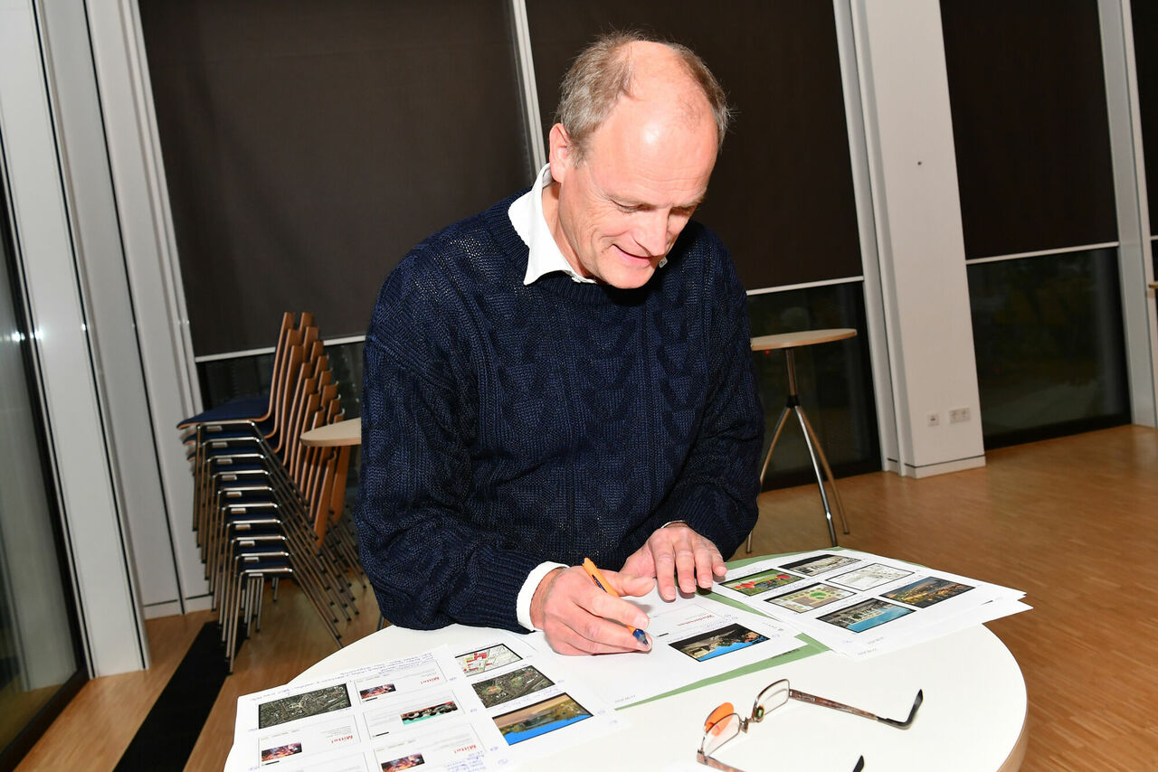 Mainzer Architekturquartett: Architekt am Stehtisch mit bebilderten Unterlagen.