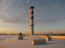 Blick auf eine Landschaft mit Leuchtturm im Schnee.