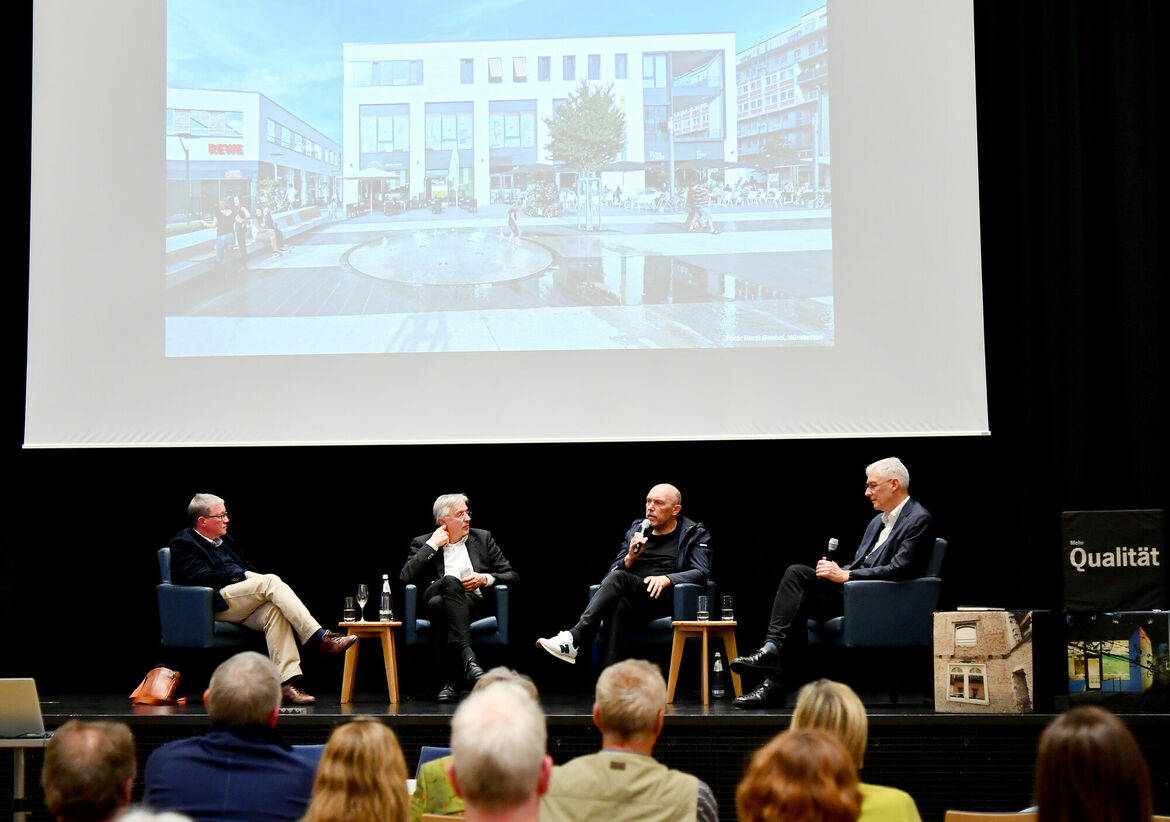 Mainzer Architekturquartett: vier Personen sitzend auf einer Bühne mit Projektion im Hintergrund