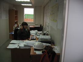 Aviva Klingel sitzt telefonierend am Schreibtisch in ihrem Büro und lacht in die Kamera.