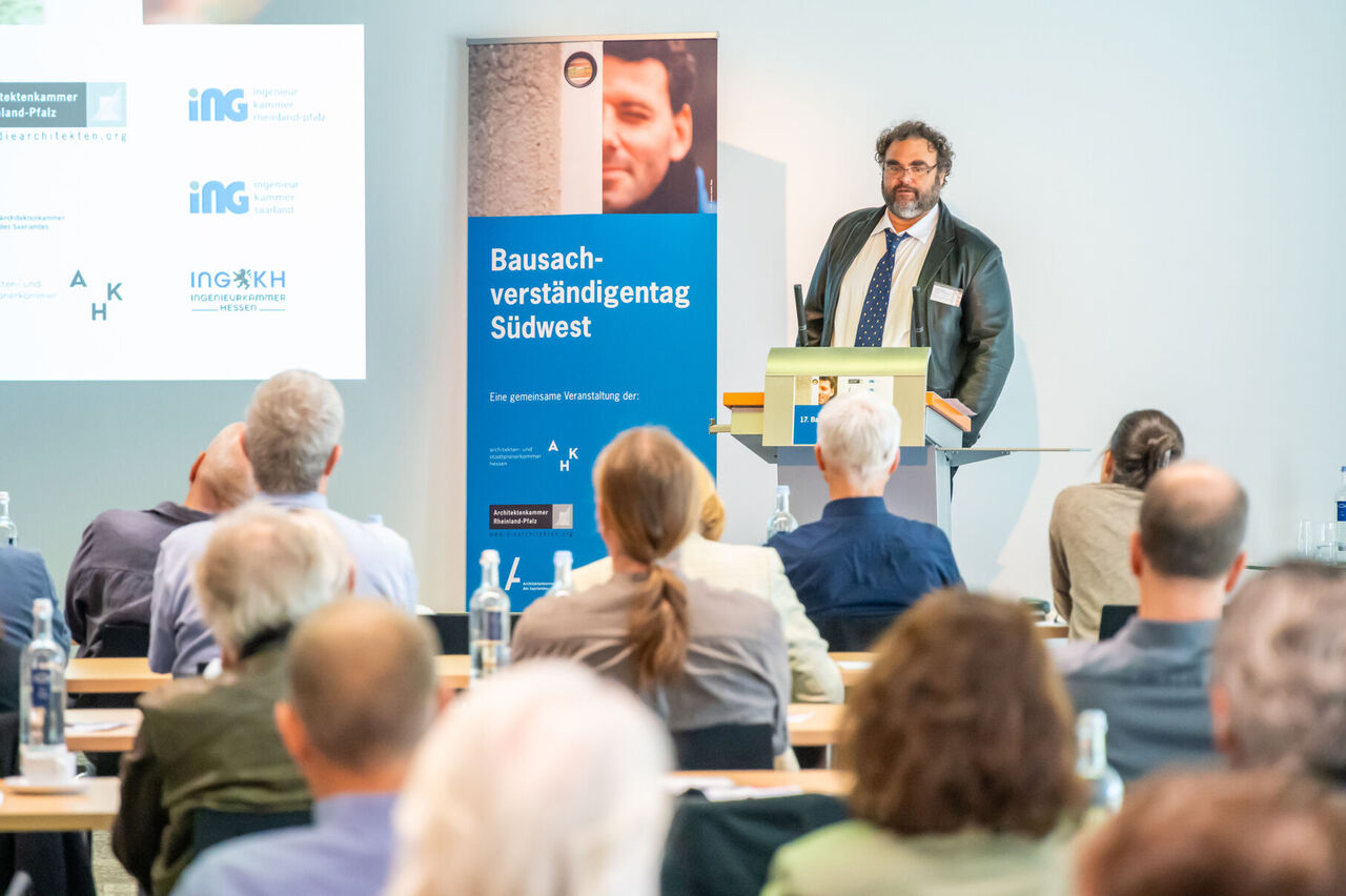 Holger Beger steht am Rednerpult bei seinem Vortrag