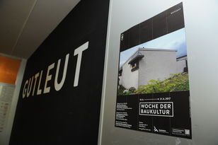 Blick auf einen Innenwand mit dem Logo der Café-Bar Gutleut und daneben das Plakat zur Veranstaltungsreihe.