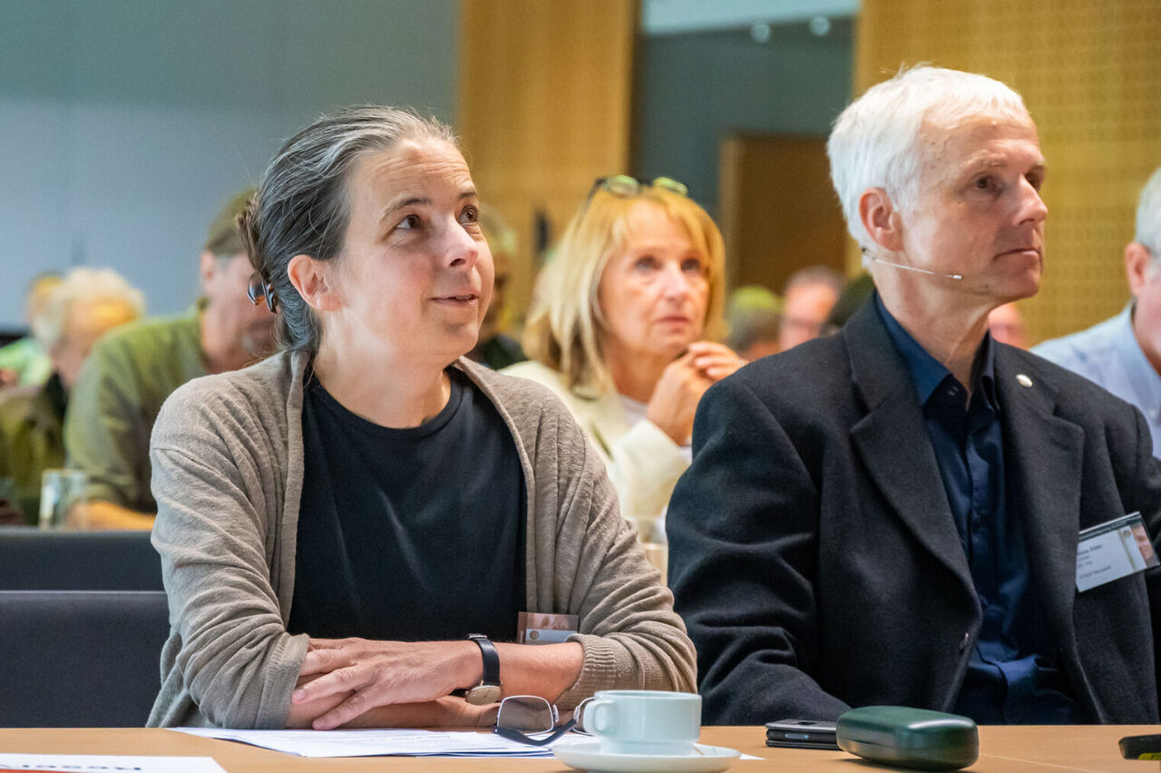 Edda Kurz und Prof. Zöller sitzen in der ersten Reihe des Publikums