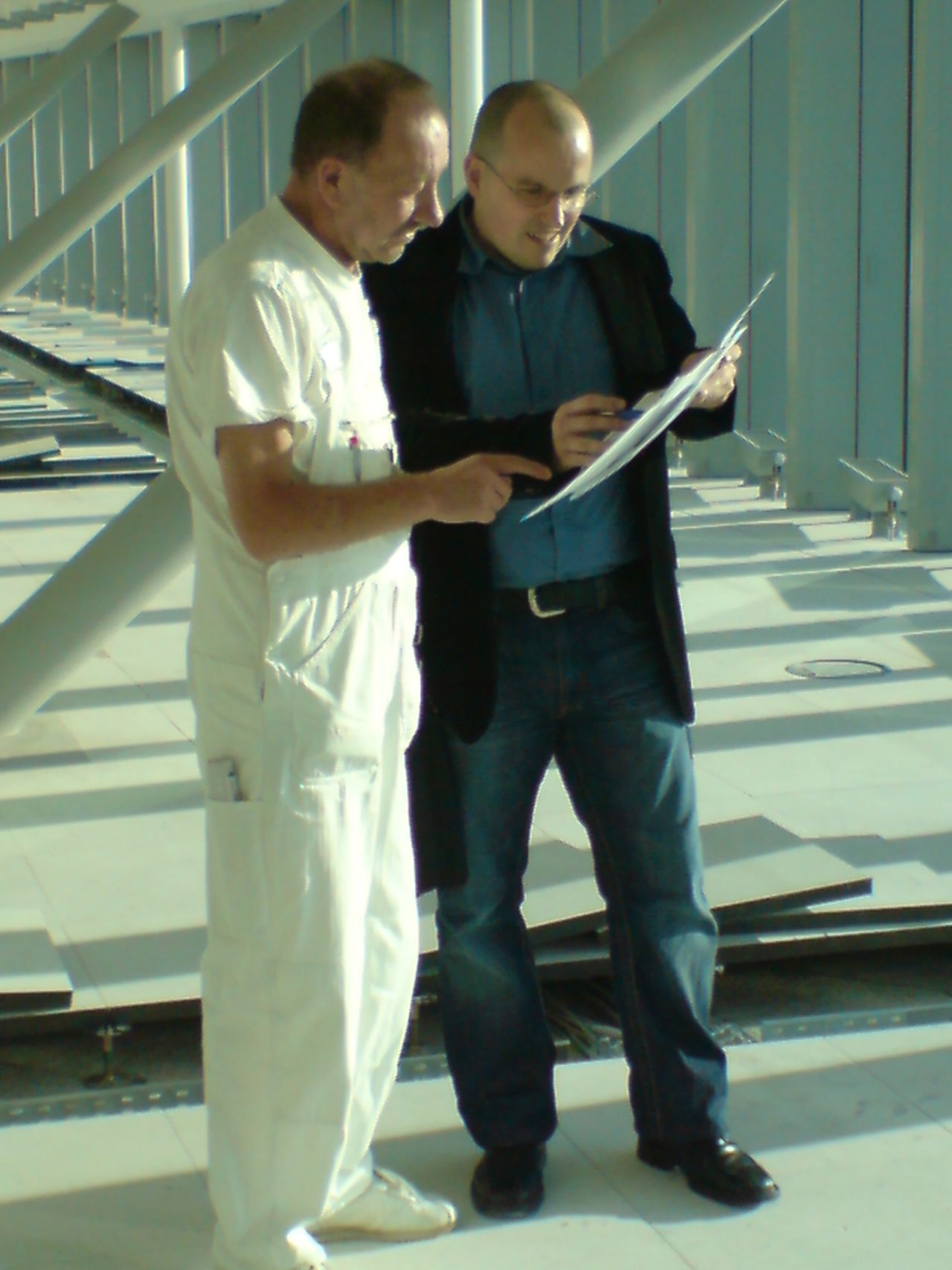 Andreas Scherer bespricht sich mit einem anderen Mann auf der Baustelle.