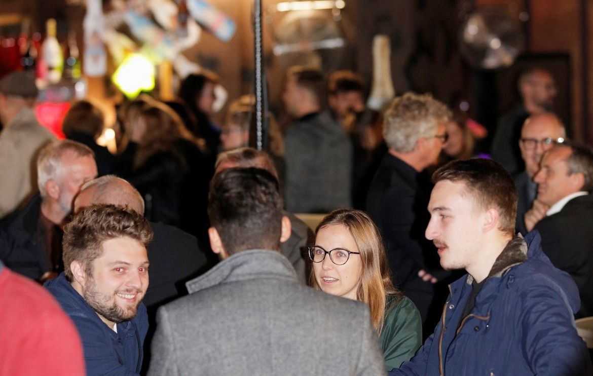 Blick in einen Club mit vielen Besuchern und einem hoch aufgebauten Beamergerät in der Mitte des Fotos.